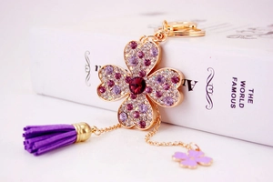 Dettaglio portachiavi a quadrifoglio con strass viola, finitura oro e frangia chic