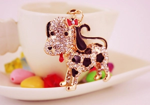 Détail du porte-clés dalmatien doré avec strass scintillants et nœud rouge élégant