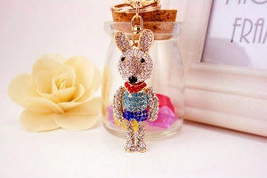 Close-up of cute cartoon rabbit keychain featuring sparkling rhinestones and blue stripes