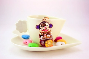 Close-up of golden cartoon monkey keychain featuring Fu character and pearl details
