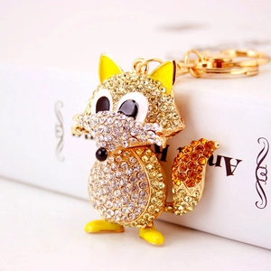 Sparkling crystal fox keychain with champagne rhinestones on a decorative book background