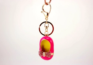 Detail showing pink enameled shoe keychain with rhinestones and gold lobster clasp