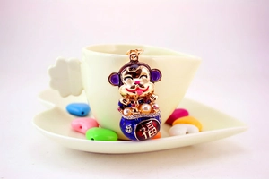 Detailed macro view of a golden monkey keychain with colorful enamel and pearl accents