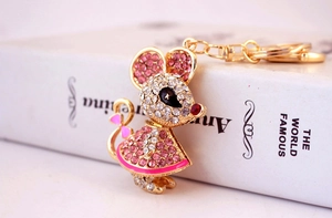 Close-up of sparkling rhinestone mouse keychain with bow detail on white book