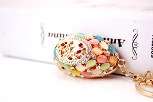 Detailed macro view of an ornate Faberge style egg keychain with colorful gemstones