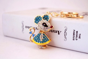 Macro shot of mouse-shaped keychain with blue and white rhinestones and a gold base