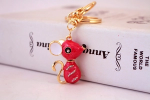 Détail macro du porte-clés souris en émail rouge avec plaquage or et strass scintillants