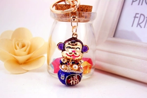 Detailed view of lucky monkey keychain with enamel colors and a fuhu gold character