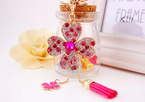 Dettaglio di un portachiavi a quadrifoglio con strass rosa e un'elegante nappa coordinata