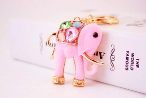 Detail of pink elephant keychain with colorful inlaid resin gems and golden metalwork