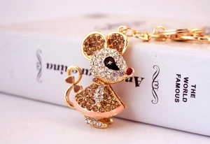 Macro detail of rhinestone-encrusted mouse keychain with pink enamel and gold finish