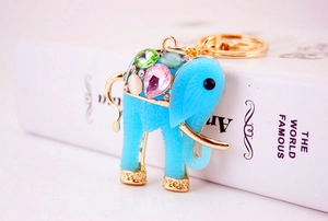 Macro shot of blue resin elephant keychain with colorful gemstones and gold accents