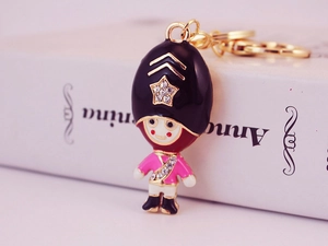 Close-up of a pink royal guard keychain with sparkling crystal star on black hat