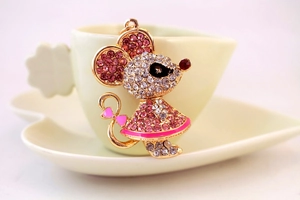Detailed view of mouse keychain with sparkling rhinestones and pink enamel bow detail