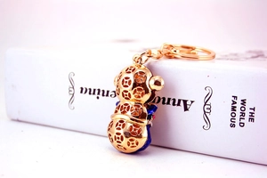 Detailed close-up of golden monkey keychain with blue enamel and pink rhinestones
