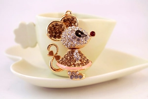 Macro shot of mouse keychain with pink enamel dress and sparkling pavé crystals