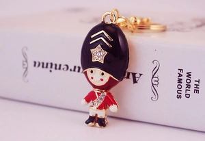 Close-up of royal guard keychain with red enamel and white rhinestones on golden metal