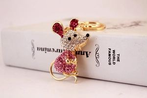 Détail du porte-clés souris en cristal avec strass colorés posé sur un livre