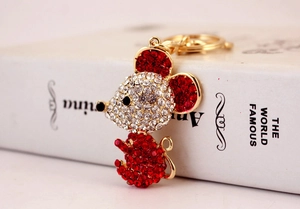 Macro shot of gold mouse keychain with red and white rhinestones on a book spine