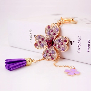 Portachiavi quadrifoglio con strass e nappa in pelle scamosciata viola e oro
