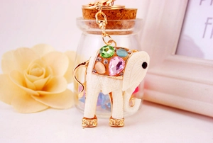 Detail of elephant keychain with colorful gemstones and engraved patterns on warm background