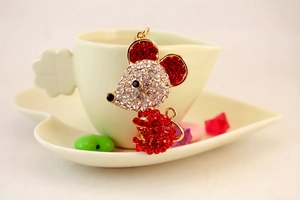 Detailed view of mouse keychain with red and white rhinestones on a heart tray
