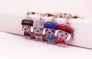 Detailed close-up of four colorful rhinestone puppy dog keychains in poodle shapes
