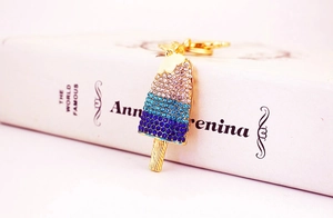 Detail of ice cream keychain with blue and white crystals in pavé setting on gold base