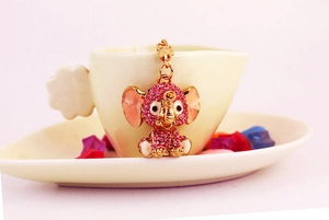 Detail of pink rhinestone elephant keychain featuring gold metal and enamel accents
