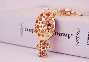 Detail view of a gold metal royal guard keychain with hollow polka dot design
