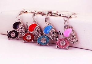 Vue macro de porte-clés chien ornés de strass colorés en noir, rouge, bleu et rose