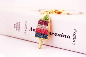 Macro shot of ice cream keychain with colorful rhinestones on a gold metal base