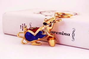 Detailed view of golden mouse keychain with red enamel patterns and Fu character engraving