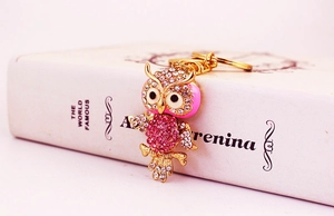 Detailed view of owl keychain with pink and red rhinestones on a golden alloy frame