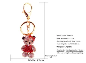 Vue détaillée du porte-clés ours en strass rose et rouge avec un nœud et clip doré