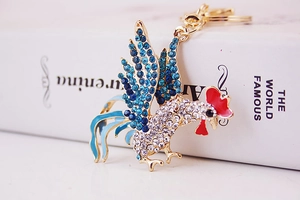 Detailed close-up of golden rooster keychain with sparkling rhinestones and blue enamel