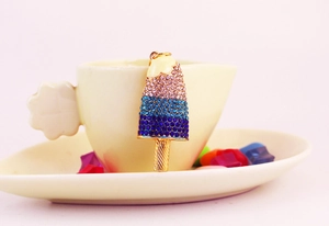 Detail of colorful ice cream keychain with pink and blue rhinestones on white cup