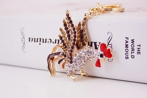 Detail view of crystal rooster keychain with gold lobster clasp and sparkling rhinestones