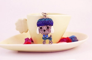 Detailed close-up of a blue rhinestone dog keychain hanging on a beige ceramic coffee cup