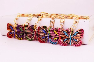 Detailed macro view of colorful rhinestone butterfly keychains with golden lobster clasps
