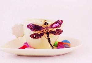 Vue détaillée d'un porte-clés libellule en cristal violet sur une tasse en porcelaine
