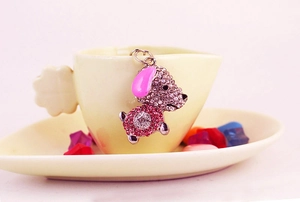 Détail d'un charmant chiot serti de strass roses pour porte-clés ou accessoires
