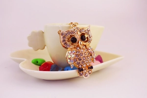 Détail du porte-clés hibou doré avec strass scintillants et grands yeux noirs