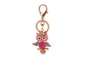 Close-up of pink and white rhinestones on golden owl keychain accessory with carabiner