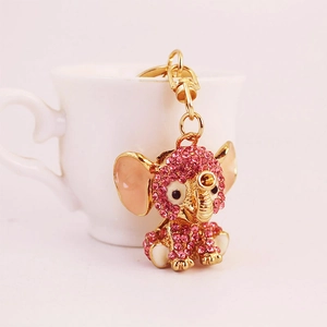 Cute pink rhinestone elephant keychain with gold alloy lobster clasp on ceramic cup