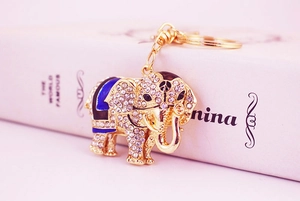 Macro shot of gold elephant keychain with white rhinestones and blue enamel details