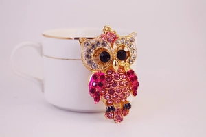 Détail du porte-clés hibou avec strass roses et plaqué or sur une tasse en céramique