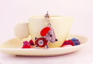 Détail d'un porte-clés chiot avec strass rouges et blancs suspendu à une tasse