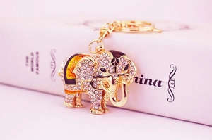 Macro shot of gold elephant keychain with white rhinestones and purple enamel detailing
