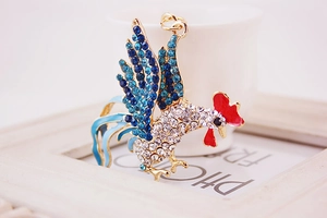 Detailed close-up of a sparkling gold rooster keychain with colorful crystal embellishments